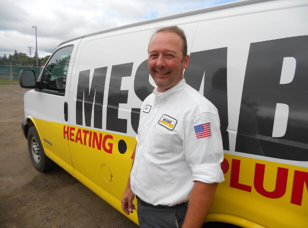 A Mesaba Employee standing in front of a company truck.